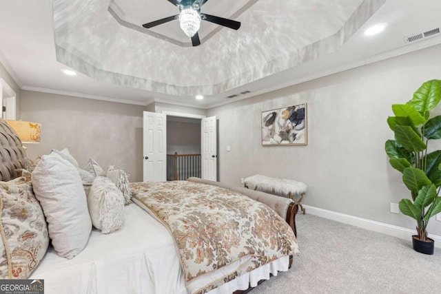 carpeted bedroom with ornamental molding, ceiling fan, and a tray ceiling