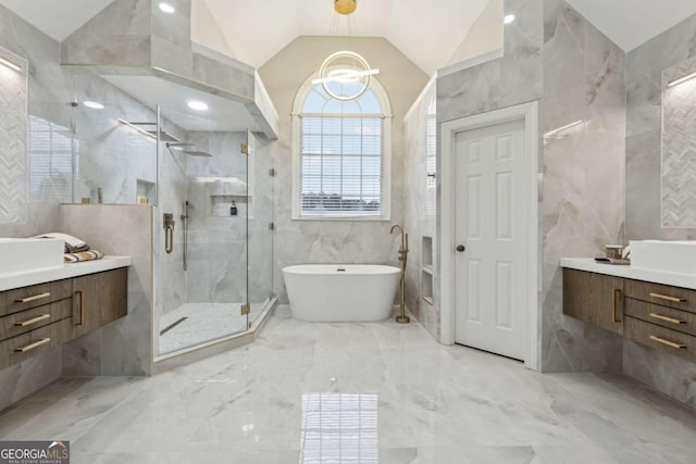 bathroom featuring vanity, vaulted ceiling, independent shower and bath, and tile walls