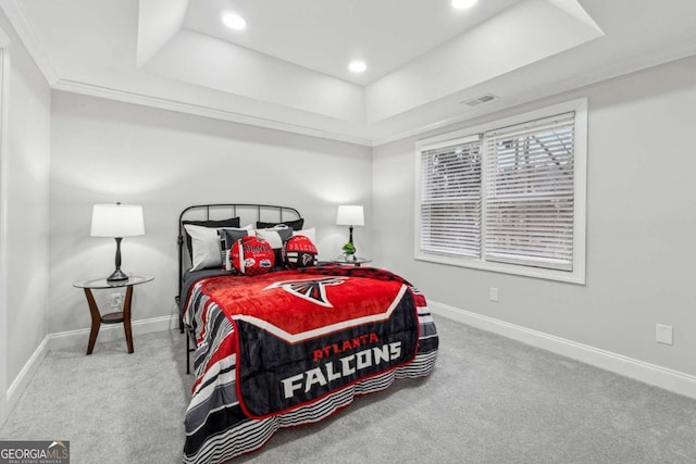 carpeted bedroom featuring a raised ceiling and crown molding