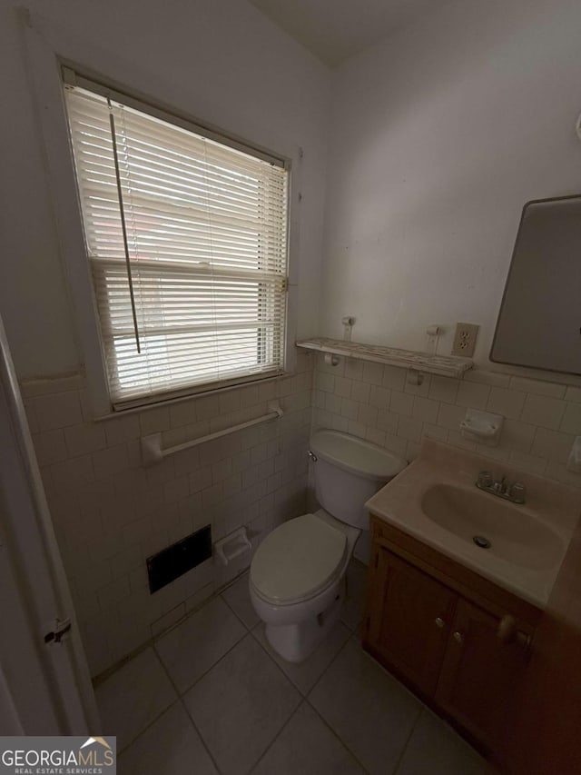 bathroom with tile walls, vanity, tile patterned floors, and toilet