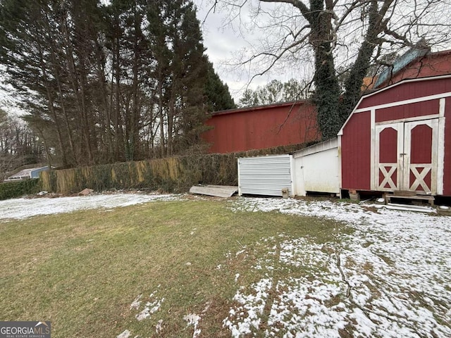 yard covered in snow featuring a shed