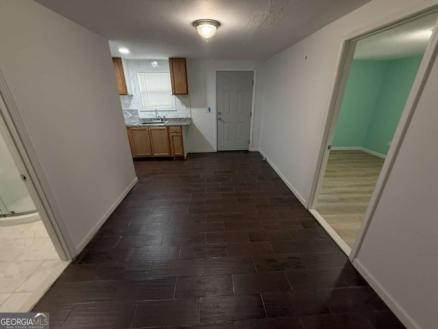 hallway with sink and a textured ceiling