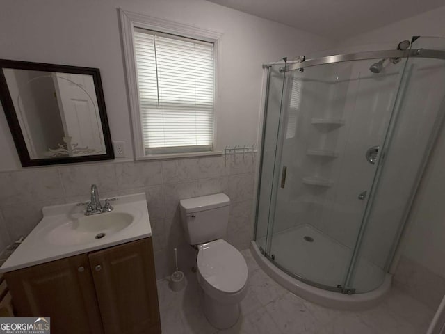 bathroom with vanity, an enclosed shower, tile walls, and toilet