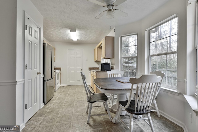 dining space with ceiling fan and a textured ceiling