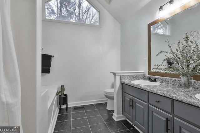 bathroom featuring vanity, vaulted ceiling, toilet, and a healthy amount of sunlight