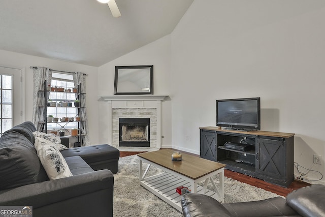 living room with ceiling fan, lofted ceiling, hardwood / wood-style floors, and a tile fireplace