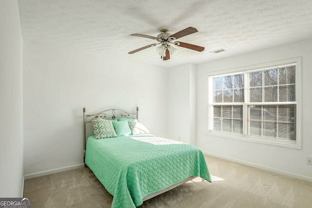 bedroom with carpet flooring, a textured ceiling, and ceiling fan