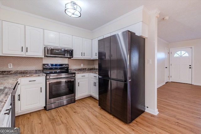 kitchen featuring tasteful backsplash, light wood-type flooring, white cabinets, and appliances with stainless steel finishes