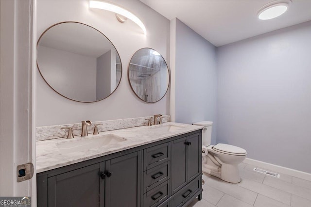 bathroom featuring vanity, tile patterned floors, and toilet