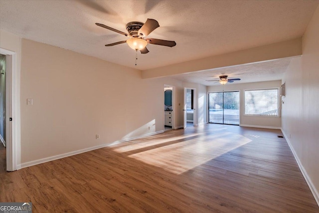 unfurnished room with ceiling fan, hardwood / wood-style floors, and a textured ceiling