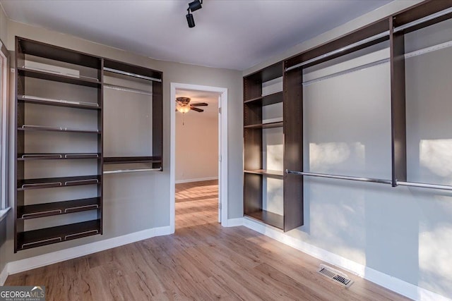 spacious closet featuring ceiling fan and light hardwood / wood-style floors