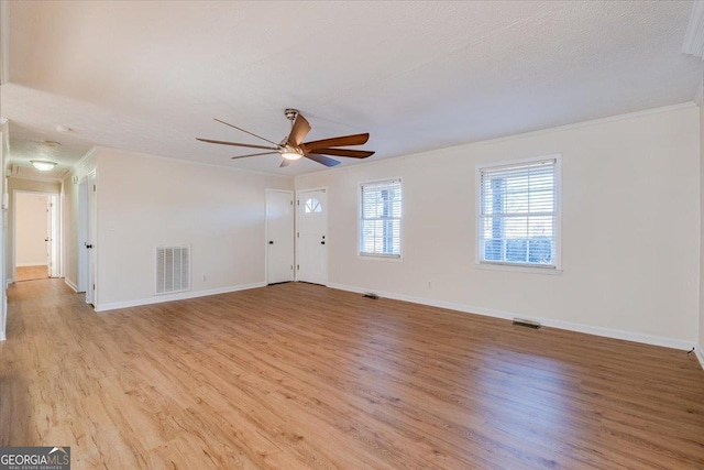 unfurnished living room with ceiling fan, ornamental molding, a textured ceiling, and light hardwood / wood-style floors