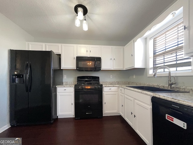 kitchen with sink, white cabinetry, light stone counters, a textured ceiling, and black appliances