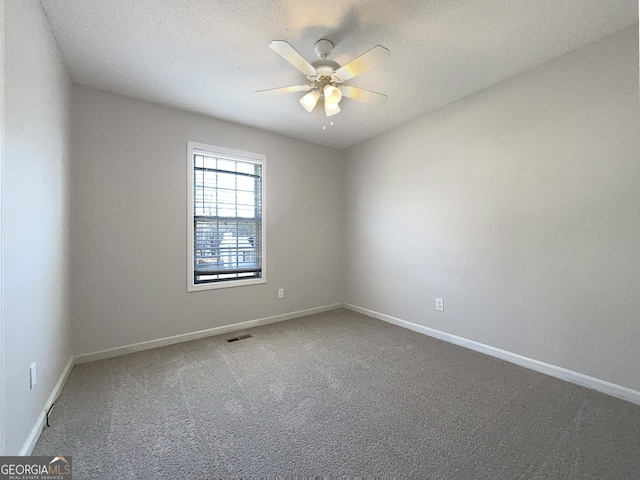 carpeted spare room featuring a textured ceiling and ceiling fan