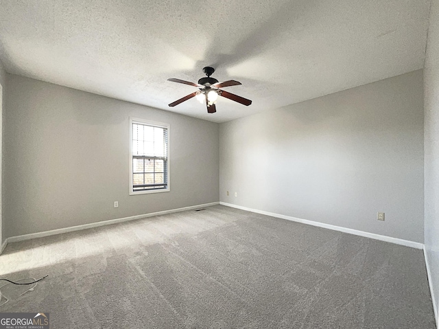 carpeted empty room featuring ceiling fan and a textured ceiling