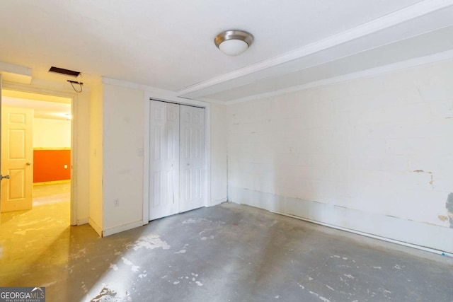 unfurnished bedroom featuring concrete flooring and a closet