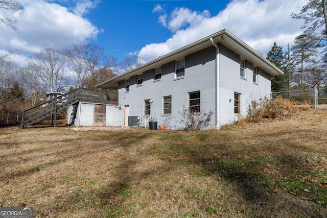 view of side of property with a wooden deck, a yard, and cooling unit