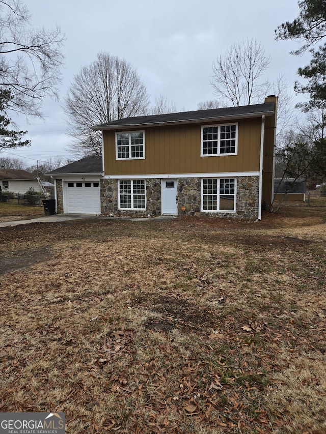 view of front facade featuring an attached garage, stone siding, and a chimney