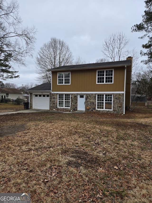 view of front of home featuring a garage, stone siding, and a chimney