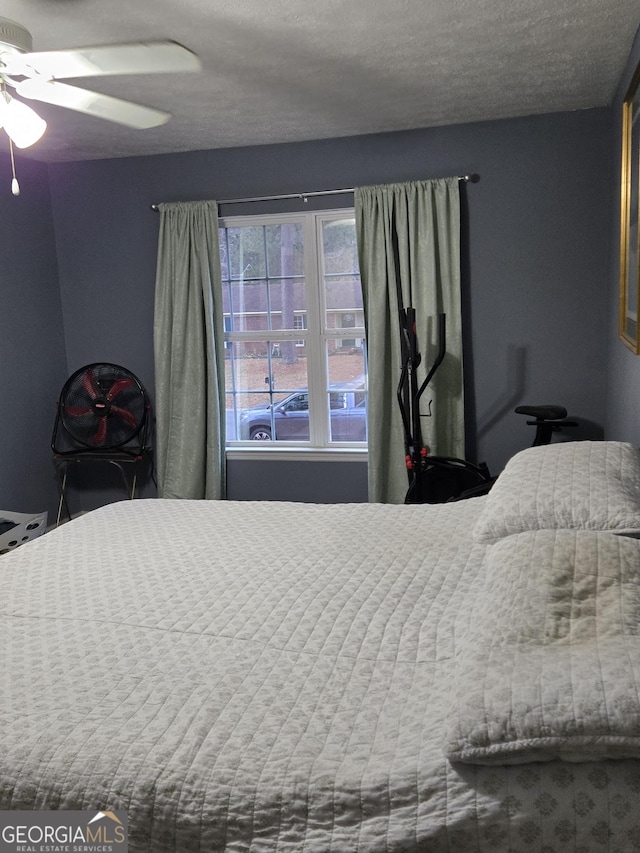 bedroom with a textured ceiling and ceiling fan