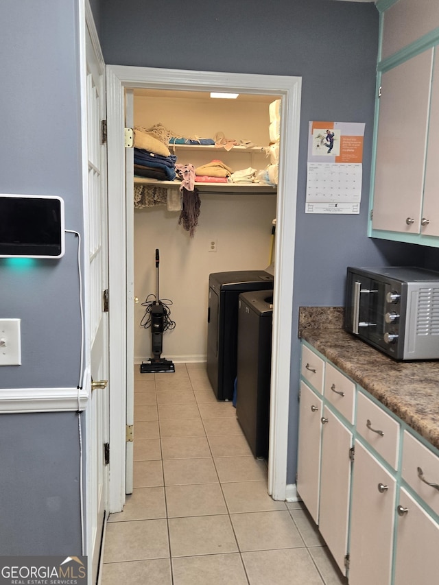 kitchen featuring white cabinetry, separate washer and dryer, and light tile patterned floors