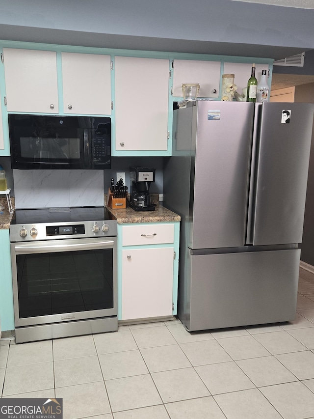 kitchen with appliances with stainless steel finishes, light tile patterned floors, and white cabinets