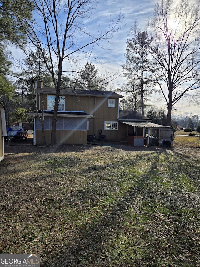 rear view of house featuring a lawn