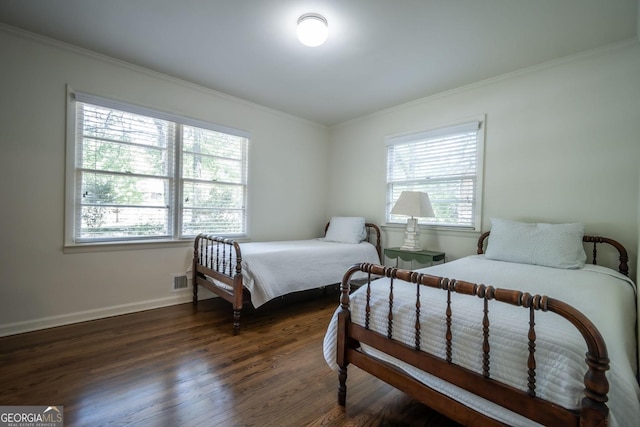 bedroom with ornamental molding and dark hardwood / wood-style flooring