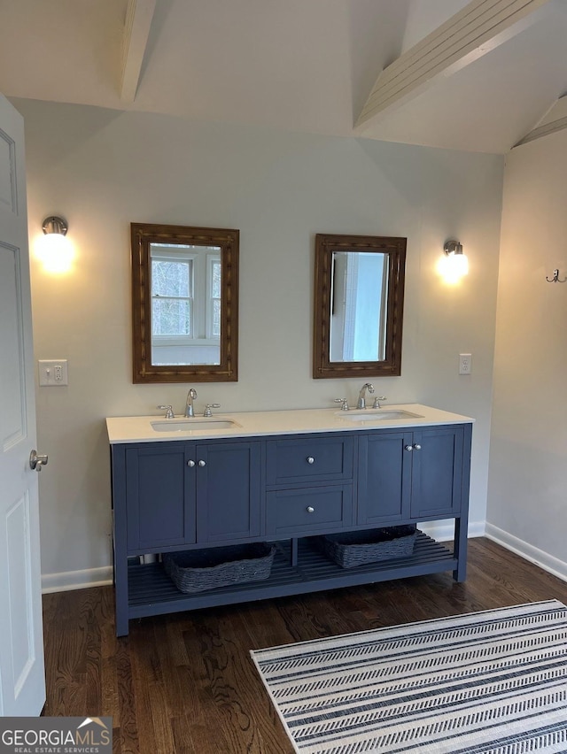 bathroom featuring vaulted ceiling, wood-type flooring, and vanity