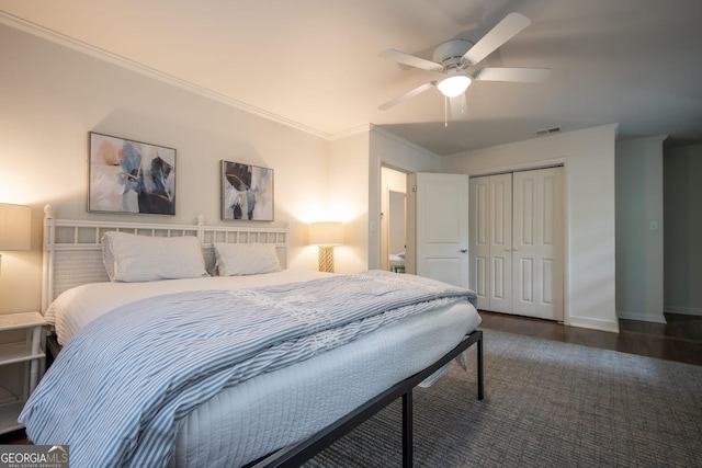 bedroom with ceiling fan, ornamental molding, dark hardwood / wood-style floors, and a closet