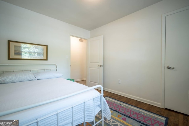 bedroom with dark wood-type flooring