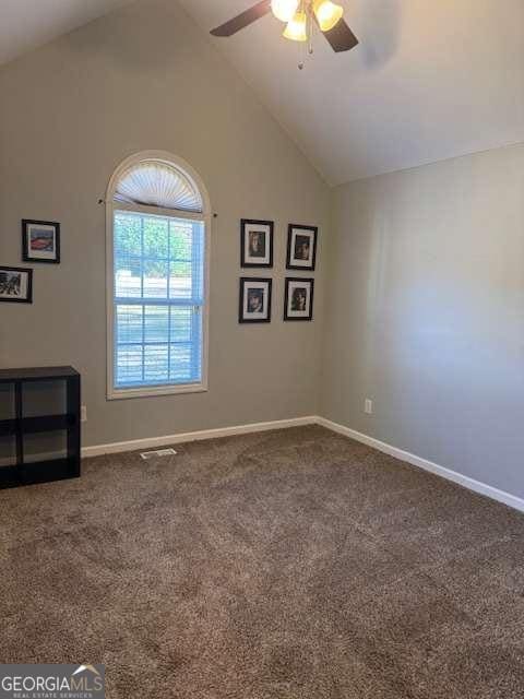 carpeted spare room with high vaulted ceiling and ceiling fan