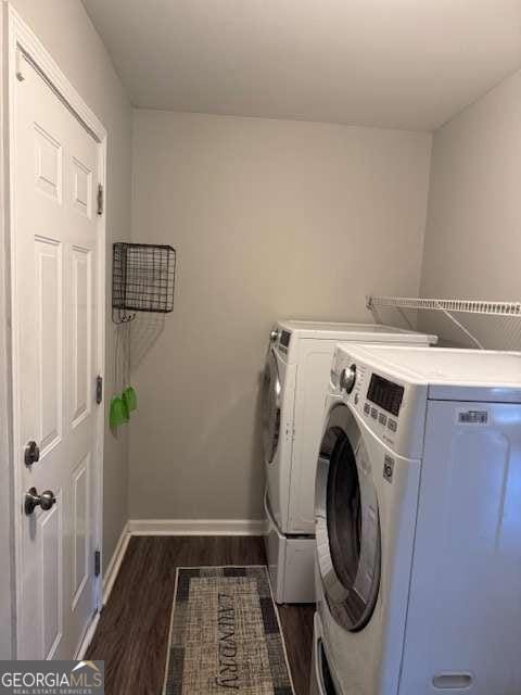 clothes washing area featuring dark hardwood / wood-style flooring and separate washer and dryer