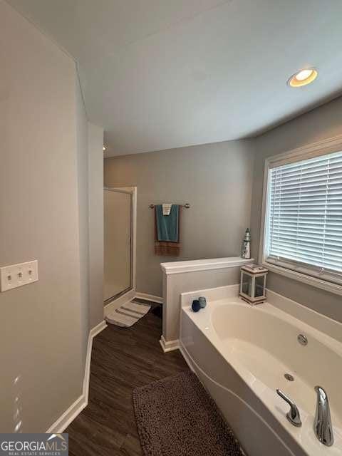 bathroom with hardwood / wood-style flooring and separate shower and tub