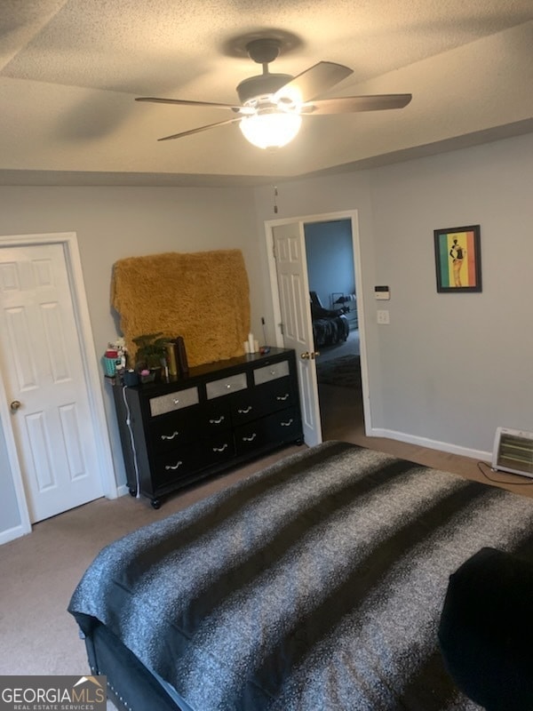 carpeted bedroom with a textured ceiling and ceiling fan