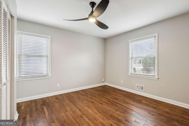 spare room with dark wood-type flooring and ceiling fan