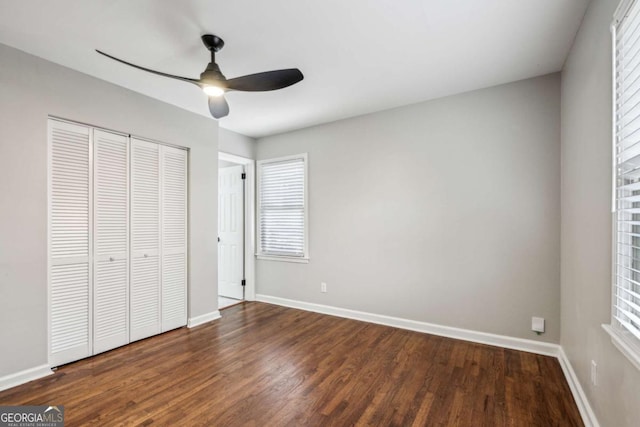 unfurnished bedroom featuring dark wood-type flooring, ceiling fan, and a closet