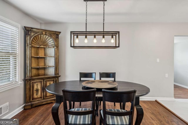 dining space with plenty of natural light and dark wood-type flooring