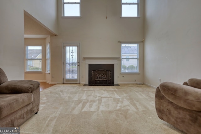 carpeted living room featuring a towering ceiling