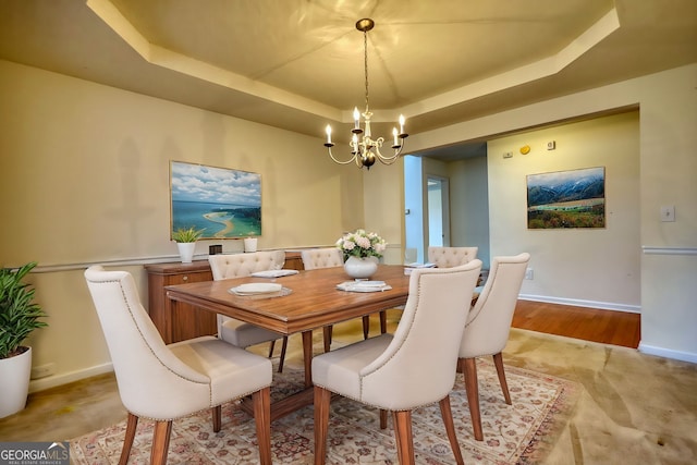 dining area featuring a tray ceiling and a notable chandelier