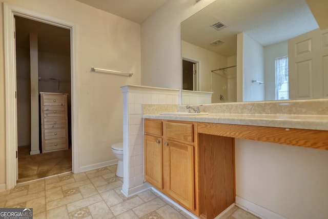 bathroom featuring vanity, toilet, and a shower