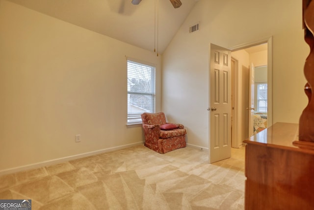 living area with vaulted ceiling, light colored carpet, and ceiling fan