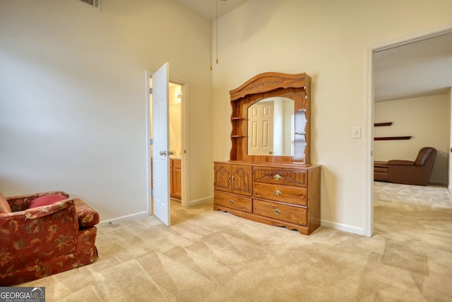 sitting room featuring light colored carpet and high vaulted ceiling