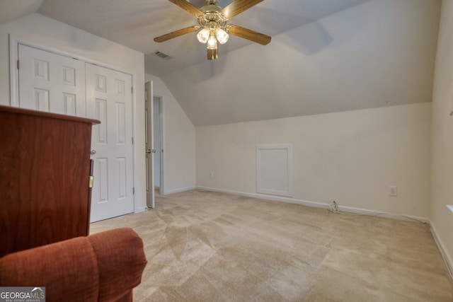 additional living space with vaulted ceiling, light carpet, and ceiling fan