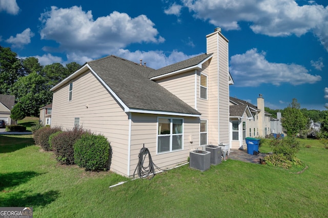 view of side of property with a yard and central air condition unit