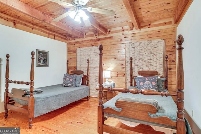 bedroom with ceiling fan, wooden ceiling, beamed ceiling, and wood walls