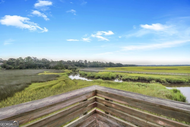 wooden terrace with a water view and a rural view