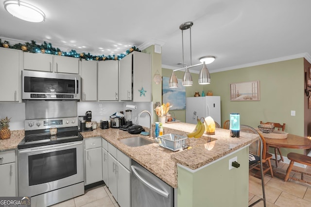 kitchen featuring pendant lighting, sink, light tile patterned floors, appliances with stainless steel finishes, and white cabinets