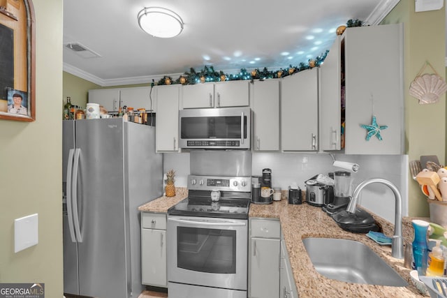 kitchen with tasteful backsplash, white cabinetry, sink, stainless steel appliances, and crown molding