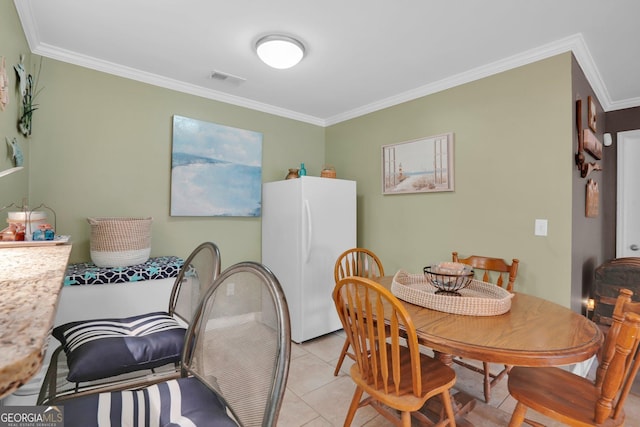 dining area with ornamental molding and light tile patterned floors